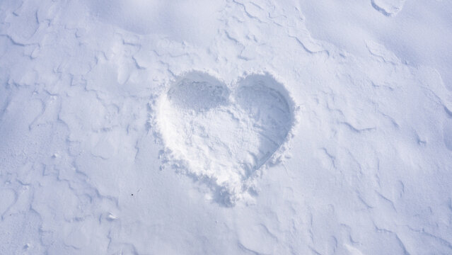 Frosty heart shape in snowy field. Romantic snow heart drawing outdoors. Winter love symbol on frozen surface. Snowflake heart detail. Snow love. - Powered by Adobe