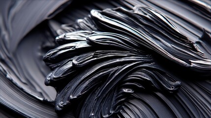 Close-up of thick, glossy black paint with swirling textures and highlights, creating an abstract and dynamic visual.