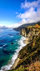 Fototapeta premium Coastal scene with cliffs, beach, turquoise water, and blue sky