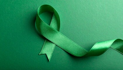 Green awareness ribbon on isolated green background. Symbol of support. Mental health awareness 