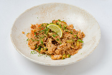 Delightful fried rice featuring tender chicken, fresh herbs, and zesty lime on a clean white dish