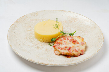 A plate of creamy mashed potatoes and a herb-garnished meat patty looks delicious