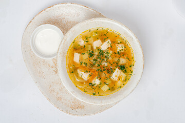 Enjoy a comforting bowl of chicken soup with tender meat, herbs, and rich broth