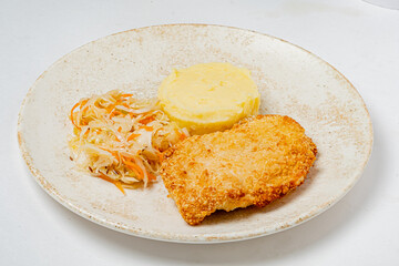 A delicious plate features crispy fish fillet, smooth mashed potatoes, and fresh coleslaw