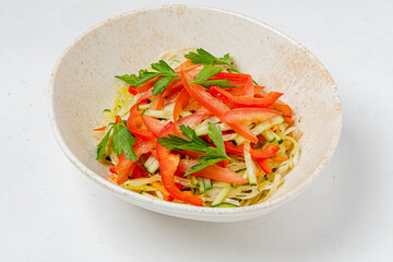 A vibrant salad made with strips of red pepper, cabbage, and fresh herbs placed in a bowl