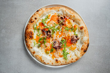 This seafood pizza features shrimp, octopus, and greens, all artfully presented