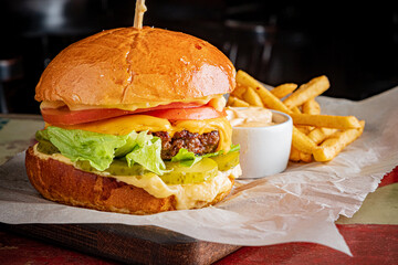 A delicious cheeseburger stacked with fresh lettuce, tomato, and pickles, served with fries