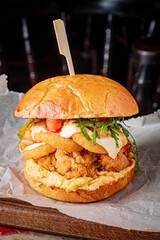 Mouthwatering chicken sandwich with crispy fried chicken, fresh greens, and sauce on a soft bun
