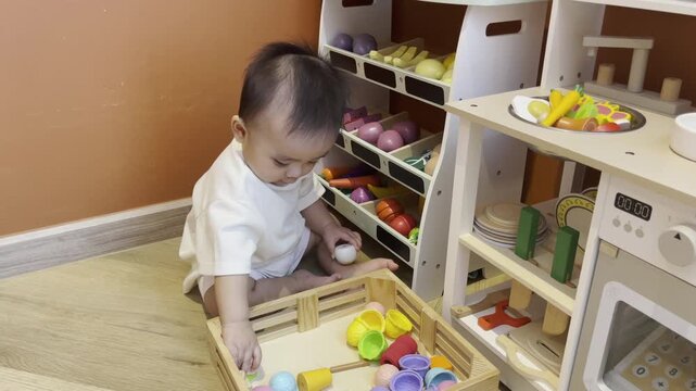 A cute little child smiles happily while playing with toys made from wood and non-toxic paint to enhance their development.