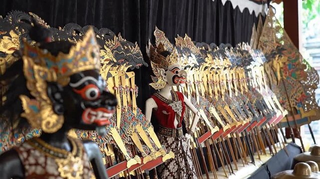 Traditional Wayang Kulit Shadow Puppets Display with Intricate Gold Detailing and Detailed Character Faces in Soft Ambient Lighting