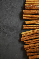 Cinnamon Sticks Neatly Arranged on Dark Stone Background for Culinary Inspiration