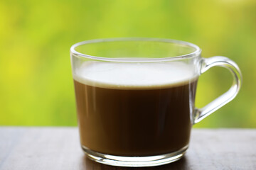 Glass Cup of Freshly Brewed Coffee Against a Vibrant Green Background