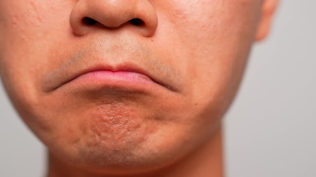This close-up of a pouty mouth highlights emotional withdrawal or stubbornness, reflecting silent objection, sadness, or a longing for comfort and attention through facial expression.
