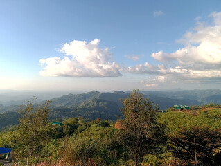 Naklejka premium Scenic mountain range with rolling hills and a picturesque cloudy sky