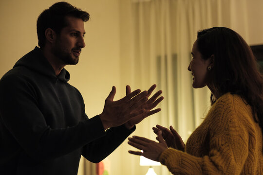 Married couple in emotional conflict and argument at home, fighting through relationship problems and difficult divorce discussions