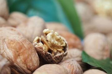 Walnuts displayed on a table with green leaves nearby