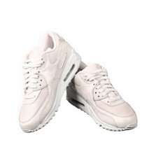 Pair of light cream colored athletic sneakers on black background