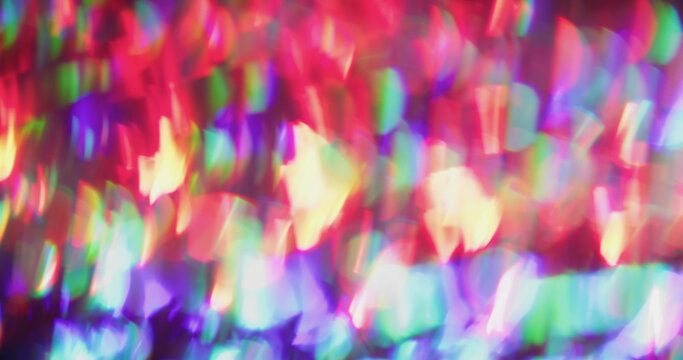 Holographic light blur. Beam prism. Red green purple circles shimmering in dark. Neon colorful reflection lens abstract background.