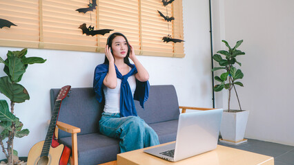 Young Woman Enjoying Relaxing Indoor Atmosphere with Laptop Surrounded by Stylish Decor in Modern Living Room Setting