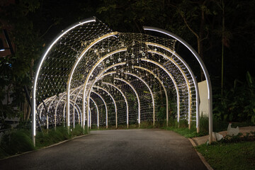 Strings of tiny star lights hang across curved frames in a bright display, and the glowing...