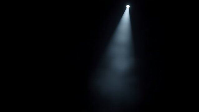 A dramatic stage spotlight cutting through a smoky atmosphere in deep darkness.