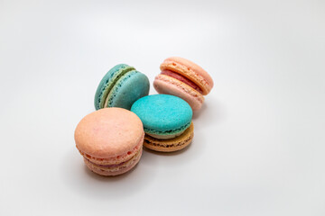 Macro studio shot of pink and blue green sweet macaron cookies on white background with copy space