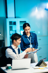 Asian colleagues discussing project plans and reviewing documents in a modern office. Concept of business teamwork, strategy