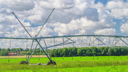 An Irrigation System Situated in a Beautiful Lush Green Field Beneath a Cloudy Sky