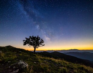 Stunning capture of a lone tree silhouetted against a vibrant night sky filled with a galaxy, overlooking layered mountains