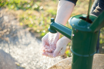 井戸の水を手動のポンプですくいあげる
