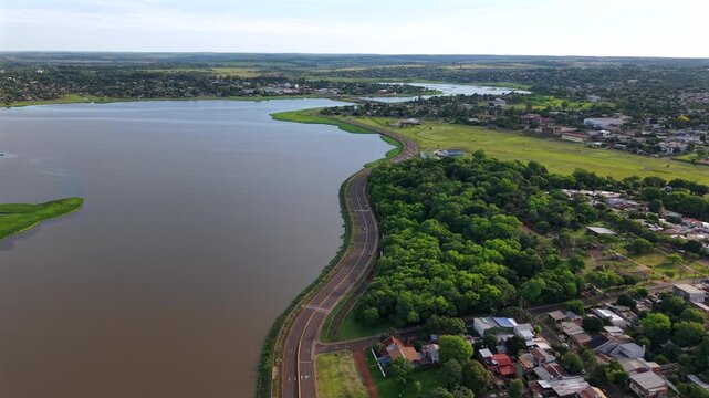 Downward drone fly over Av. Costanera road with Jardín Botánico Alberto Roth herb garden area in Posadas, Misiones, Argentina