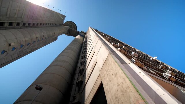 View of Belgrade&rsquo;s Genex Tower, Serbia, showcasing brutalist architecture, geometric concrete design, and its iconic presence in the urban skyline low angle aerial drone view