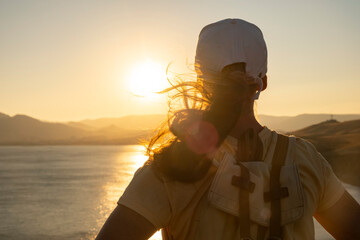 Sunset hike by the lake with a view of the mountains and golden sky