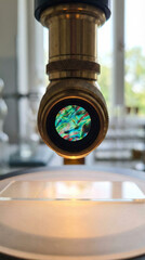 Naklejka premium Close-up of a microscope lens revealing a vibrant view through the eyepiece, ideal for scientific illustrations or educational resources.