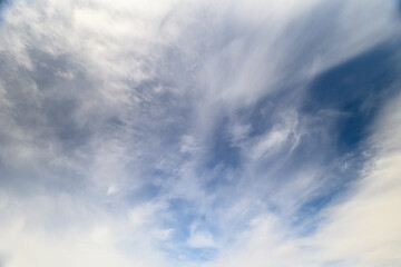 A beautiful and dreamy dynamic blue sky filled with soft, wispy clouds can be seen above