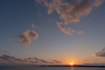 陸地に沈む夕焼けでオレンジ色の太陽