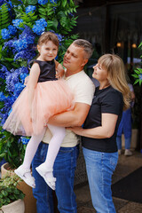 Family enjoys a joyful moment outside a cafe