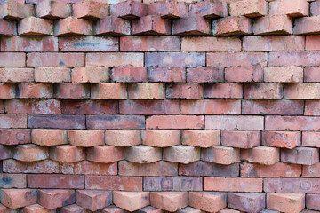An abstract pattern of vertically arranged red bricks, showcasing the texture of an industrial building and brick details, is ready for use as a graphic element.