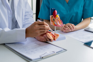 Nurse and doctor reviewing patient medical record in hospital