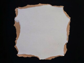 Piece of white torn paper isolated against a black background. Rough and uneven craft paper strip edges.