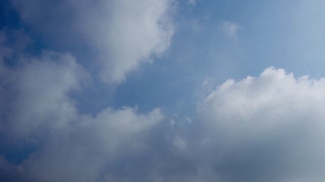 Bright airy sky with soft clouds gliding naturally in real time  recorded at normal speed showcasing atmospheric depth cloud motion natural lighting shifts and real time movement perfect for nature pr