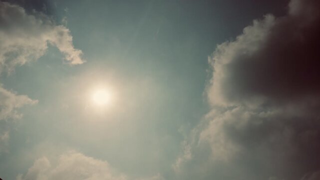 Sunlit sky with dramatic haze and soft glowing clouds moving slowly  recorded at normal speed showcasing atmospheric depth cloud motion natural lighting shifts and real time movement perfect for natur
