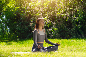 Yoga practitioner meditating in a serene outdoor setting during daylight