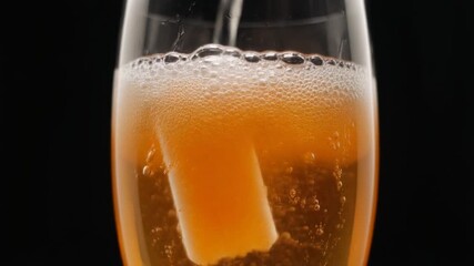 Pouring a sparkling beverage over a sugar cube in a glass, creating fizzy bubbles. - Powered by Adobe