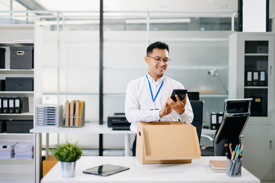 Asian businessman smiling while reading documents in a modern office.  business, workplace, productivity, and positive professional lifestyle.