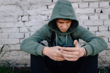 Teenager boy cyberbullying victim looking at phone © Ljustina