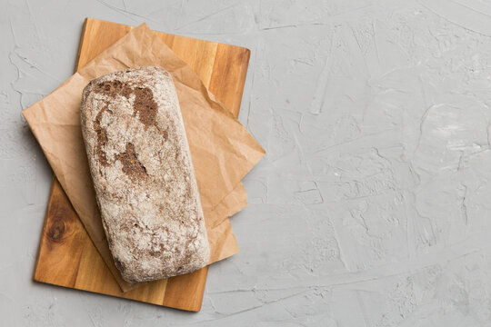 Freshly baked bread on cutting board against white wooden background. top view bread with copy space
