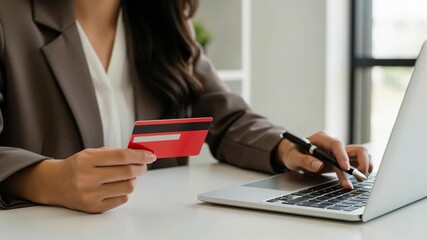 Businesswoman holding credit card and pen near laptop at desk workspace entering online payment details for invoice tax finance budget financial accounting payment debt cardholder technology