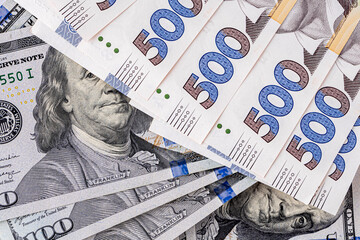 Background with Ukrainian money and American dollars.American dollars and Ukrainian hryvnias. Concept of American aid to Ukraine in the war. Concept of the exchange rate.