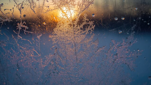 Frosty patterns on a window at sunset, serving as a seasonal background for textual content